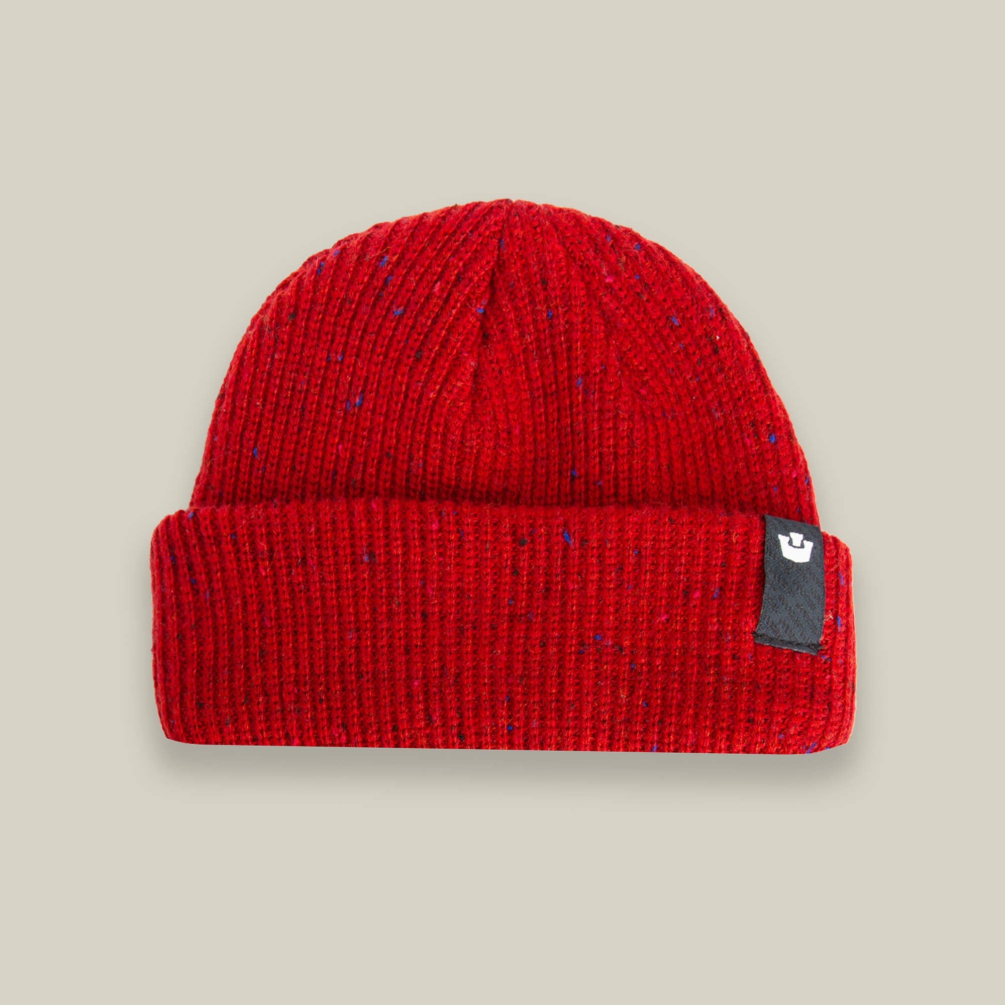 The Goorin Bros. "No Comply" beanie is a warm, red knit hat with a folded brim and a small black tag on the right side, shown on a light beige background.