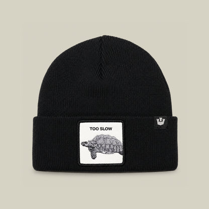 The Goorin Bros. Darn Low is a black knit beanie cap featuring a centered patch on the folded brim, with a tortoise illustration and the words “TOO SLOW” above it—an elusive drop and a true badge of honor for your collection.