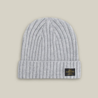 The Dream Cap by Goorin Bros. is a luxurious light gray ribbed knit beanie with a folded brim, featuring a small rectangular black and yellow label on the front.