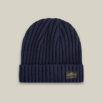 The Dream Cap by Goorin Bros. is a navy blue knitted beanie made from luxurious cashmere wool, featuring a ribbed texture, folded cuff, and a small rectangular front label, shown on a neutral background.