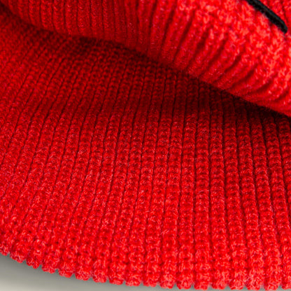 Close-up of The Strength Beanie by Goorin Bros., showcasing its red ribbed knit texture and detailed stitching that evoke rugged warmth.