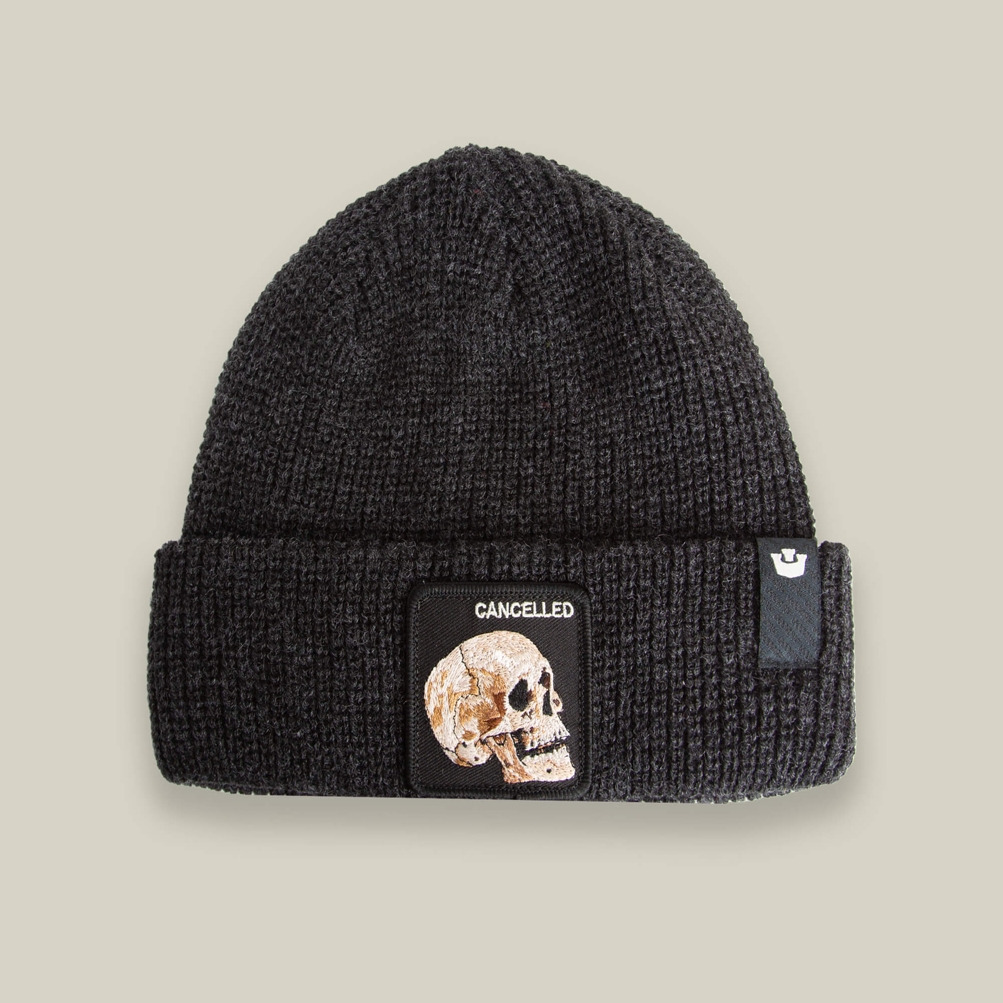 The Cancelled Beanie by Goorin Bros. in VOID features a black skull patch and "CANCELLED" front design, with a charcoal knit cuff, all showcased on a neutral background.