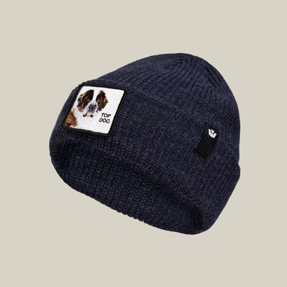 The Top Beanie by Goorin Bros. is a navy knit beanie with a St. Bernard patch featuring a dog illustration and "TOP DOG," plus a small black tag with a white paw print.