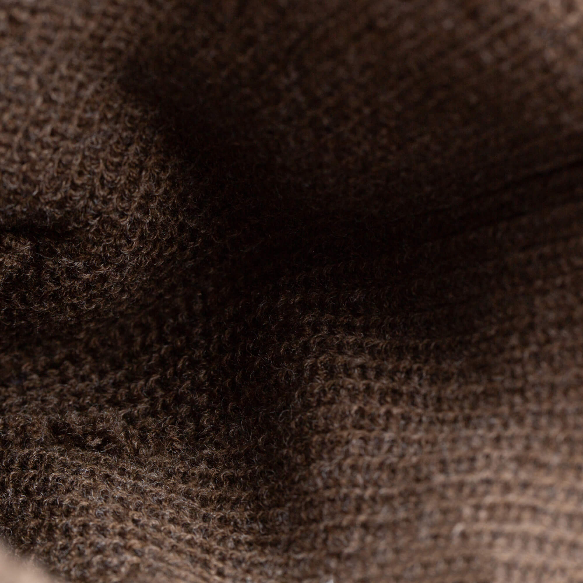 Close-up view of the interior of The Shadow Beanie by Goorin Bros., showing its dark brown knit texture and detailed woven fibers.