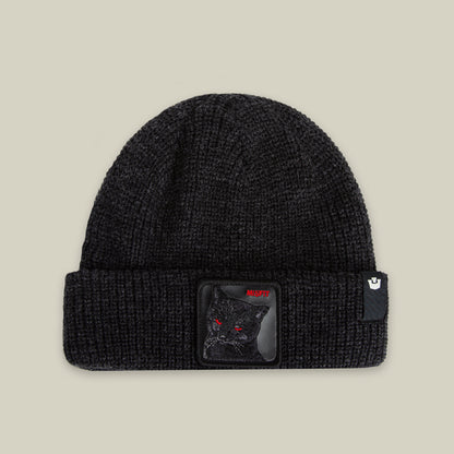 The Misfit Beanie by Goorin Bros. in VOID features a black knit design with a cat patch showing an embroidered black cat with red eyes and a small logo tag on the cuff.