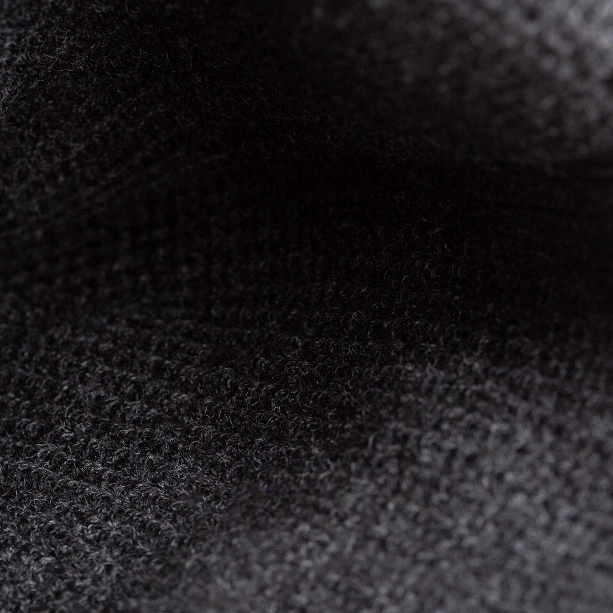 Close-up of The Deadly Beanie by Goorin Bros.—a dark, textured knit with a slightly fuzzy surface and visible weave, making it perfect for winter.