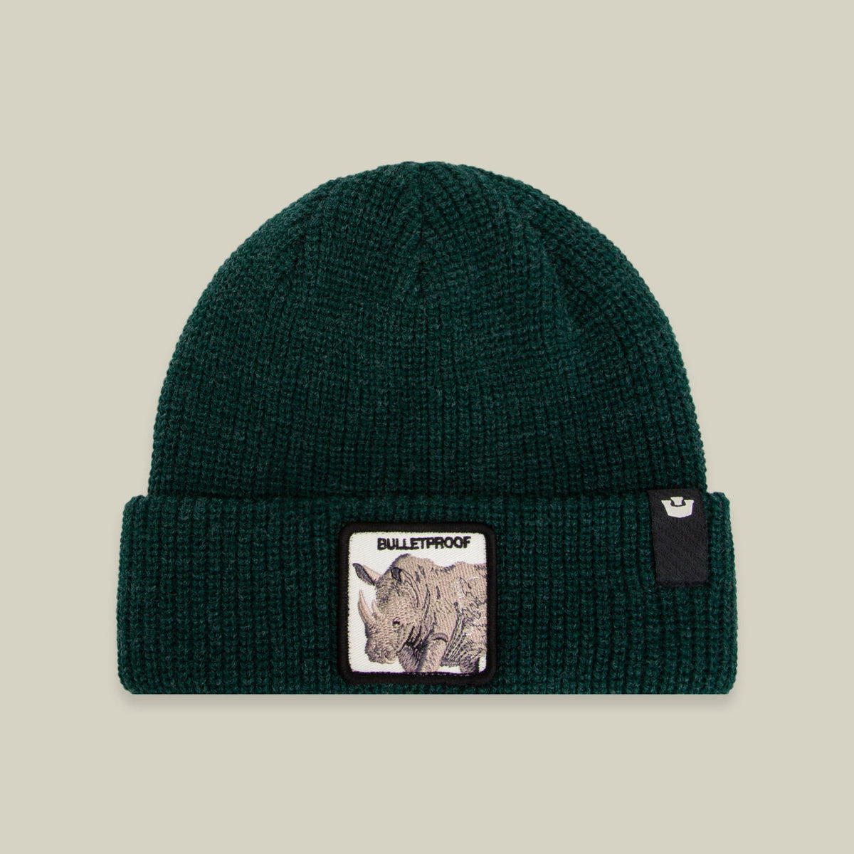 The Bulletproof Rhino Beanie by Goorin Bros is a teal green ribbed knit beanie featuring a rhinoceros patch on the front, displayed against a neutral background.