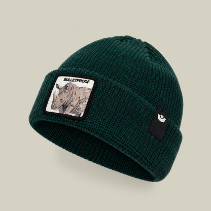 The Bulletproof Rhino Beanie by Goorin Bros is a dark forest green knit beanie featuring a rhinoceros patch on the front and a small animal logo patch on the side, displayed on a neutral background.