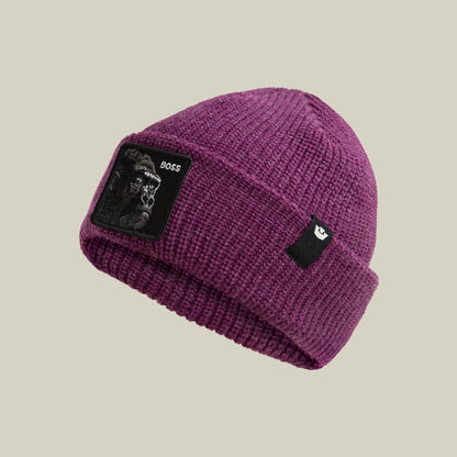The Boss Beanie by Goorin Bros. is a plum purple ribbed knit beanie featuring a black patch with a white monkey graphic and "BOSS" text on the front, displayed against a neutral background.