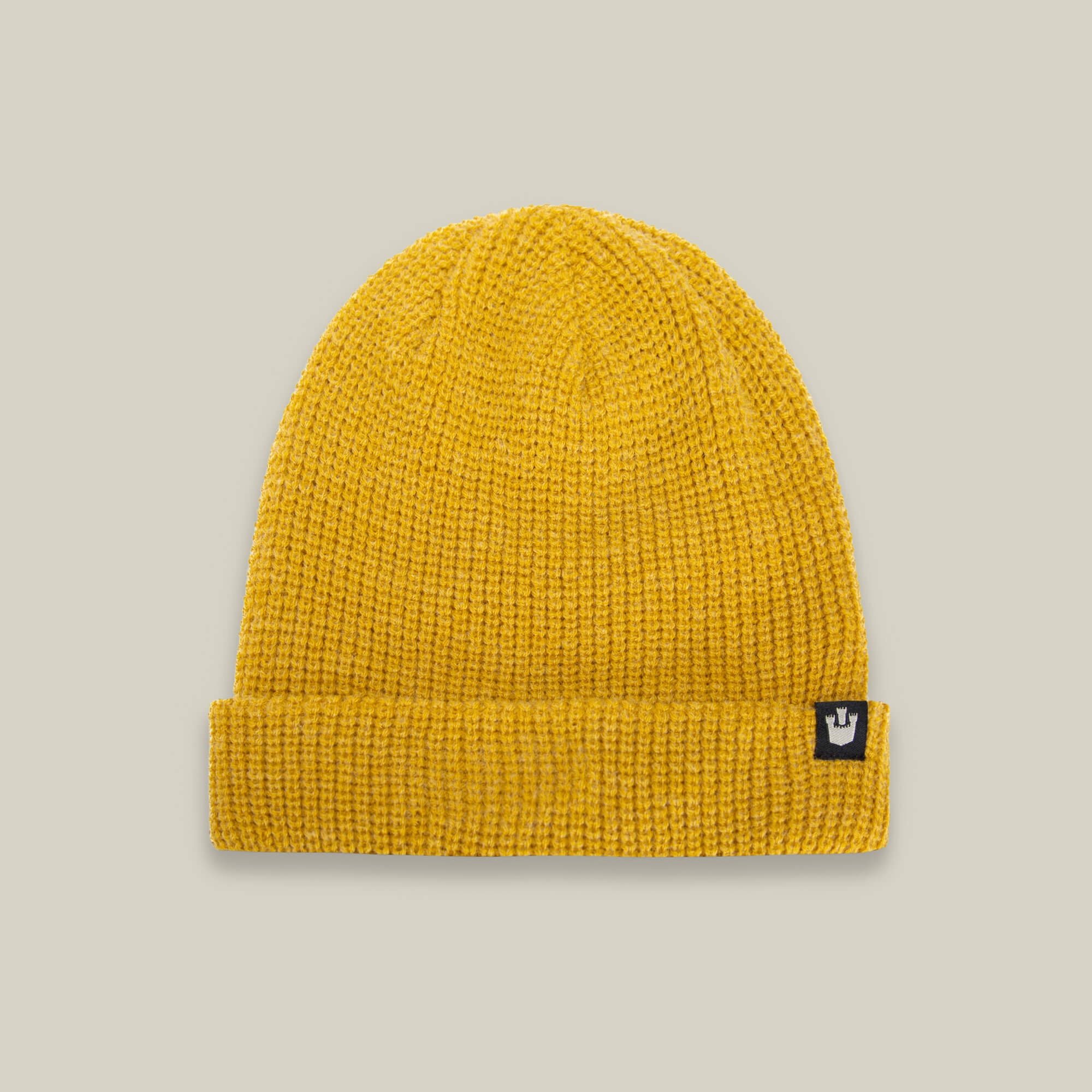 The Goorin Bros. Air to Fakie beanie in gold features a folded brim, lightweight poly knit for all-season comfort, and a small black patch with a white crown logo on the front.
