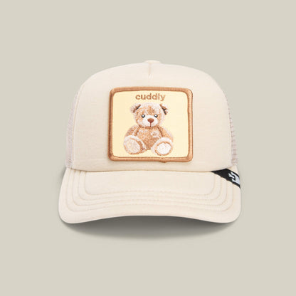 The Goorin Bros. Cuddle Time is a beige kids’ trucker hat with a mesh back, featuring a teddy bear patch and “cuddly” embroidered above—a cute and cozy cap for any child.