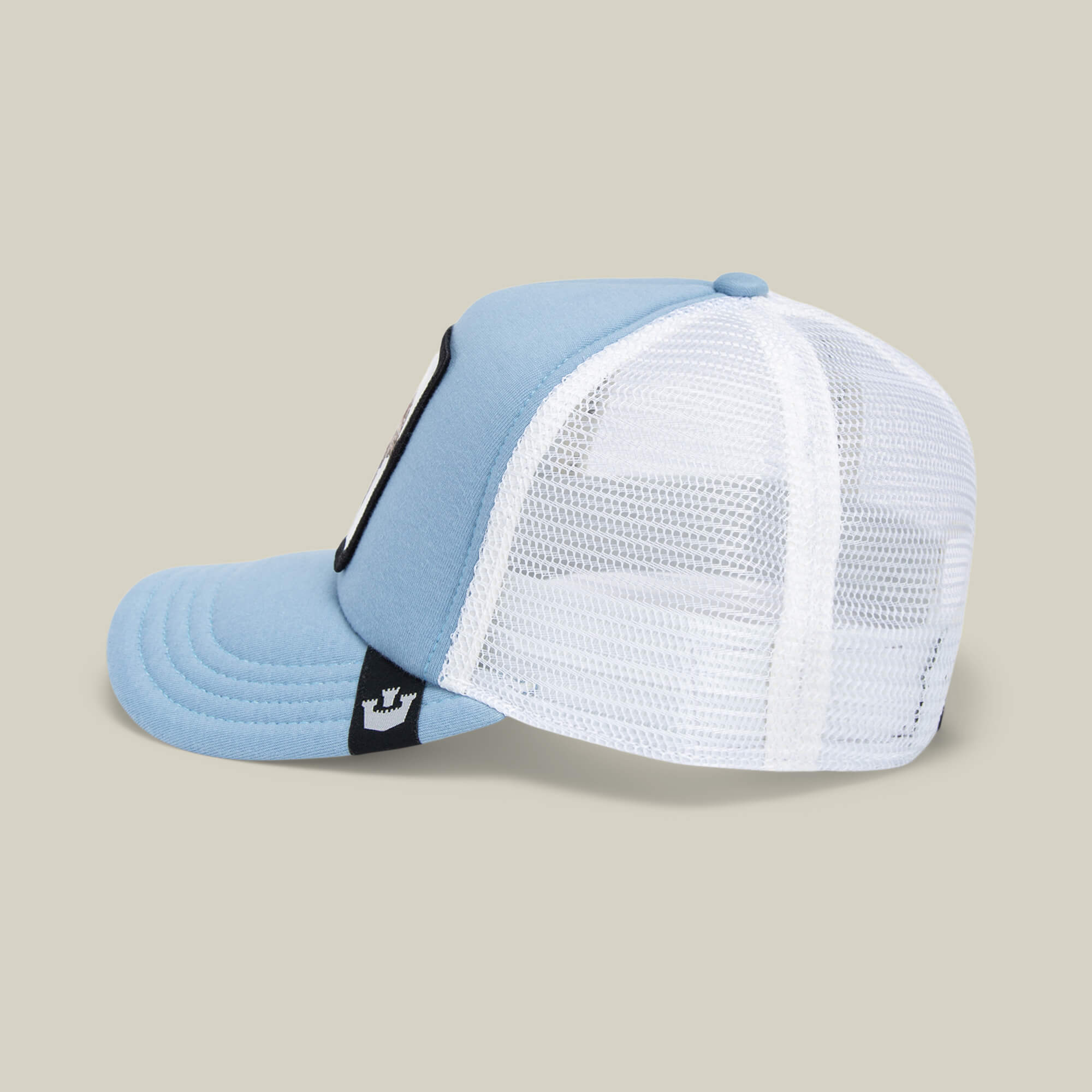 The Goorin Bros. "So Big" kids cap features light blue and white panels, sky blue mesh, and a black embroidered elephant patch on the side, shown from a side angle against a plain beige background.
