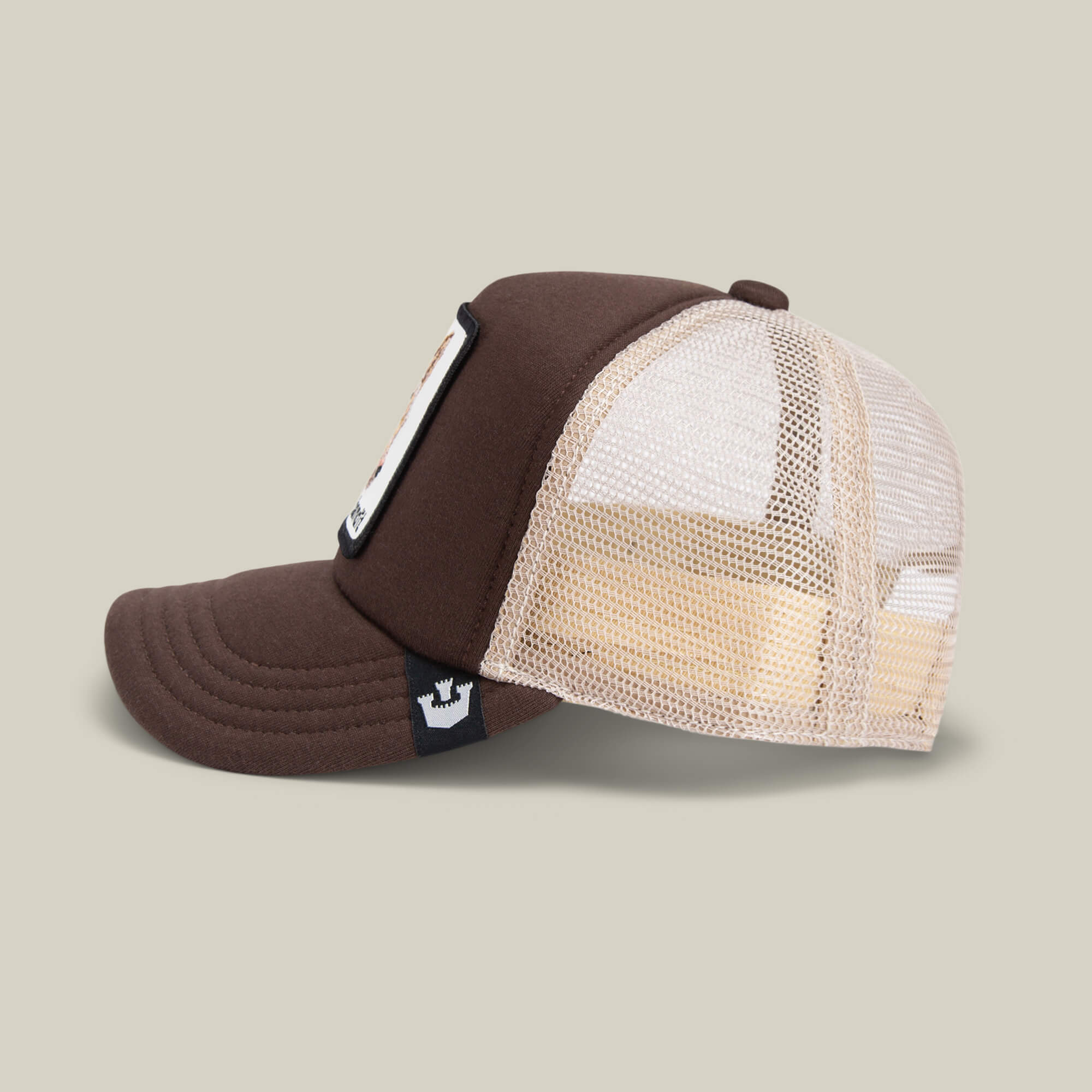The Chaser by Goorin Bros. is a brown and beige kids trucker cap with a curved brim, breathable mesh back, front patch, and adjustable snapback, shown on a neutral background.
