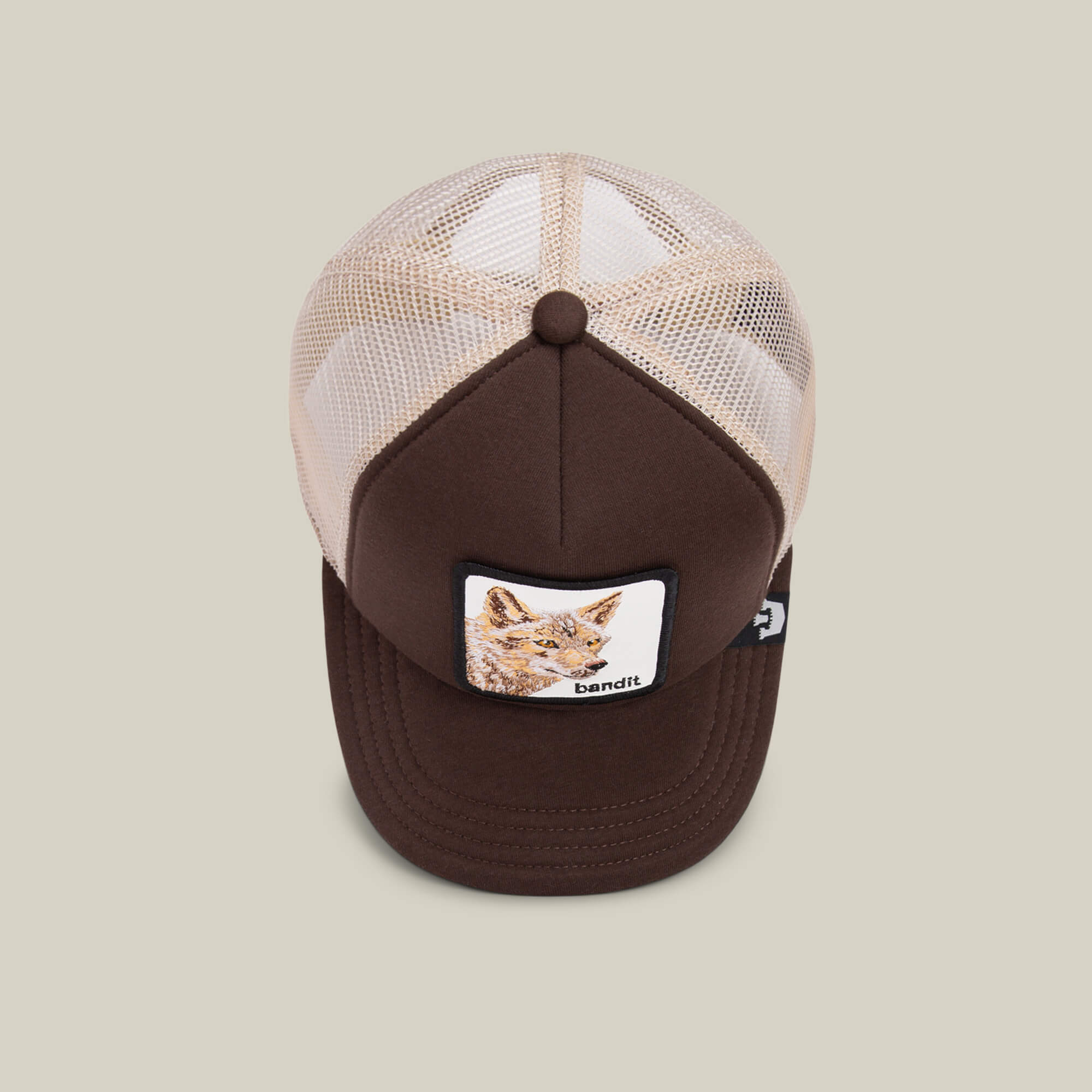 The Chaser by Goorin Bros. is a kids’ brown and beige cap with a breathable mesh back and a front patch showing an illustrated cat and the word "bandit.