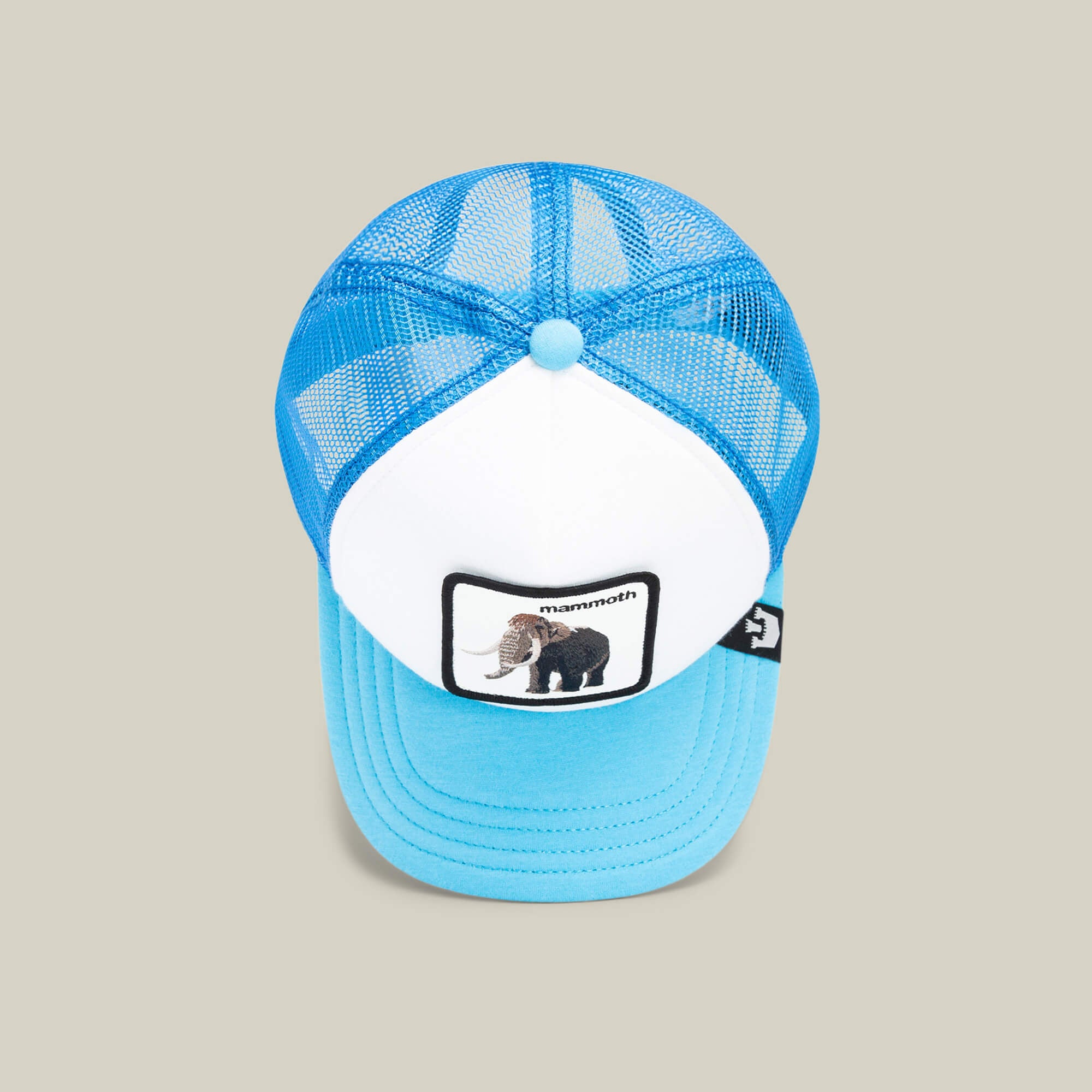 The Goorin Bros. Mammoth Kiddo is a blue and white kids’ trucker hat with a mesh back and a front patch featuring an embroidered woolly mammoth and "mammoth"—perfect for little explorers.