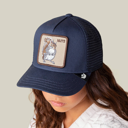 A person wearing the Goorin Bros. Nuts Mini, a navy blue trucker cap featuring a squirrel patch and "NUTS" embroidered above it.