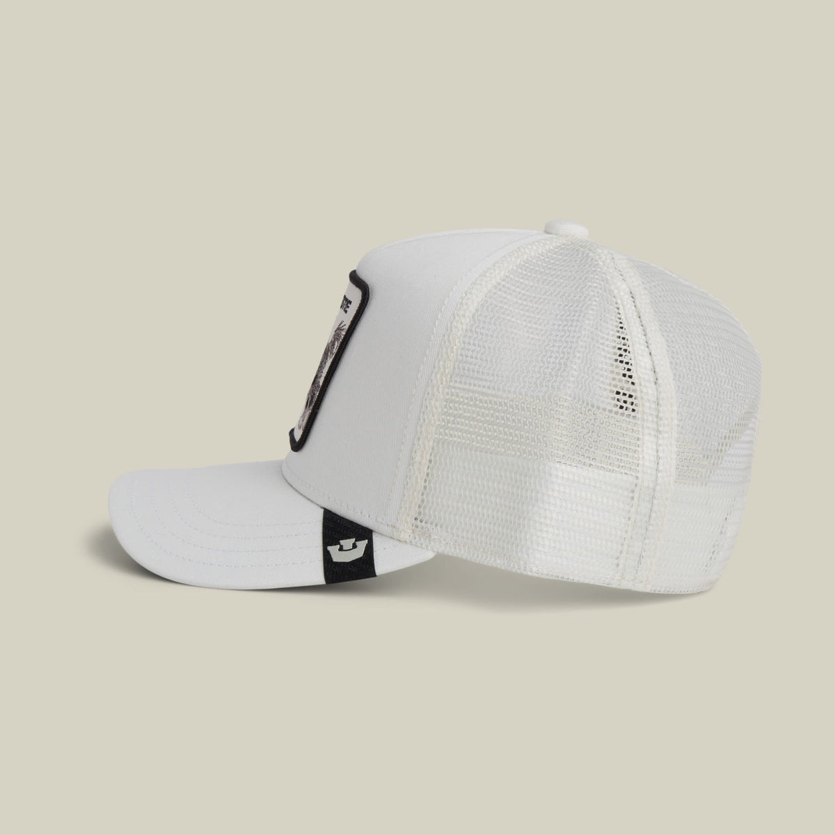 The Goorin Bros. Bestie Trucker Mini is a white mesh trucker hat with an adjustable snapback strap, shown on a neutral beige background in a studio product shot.