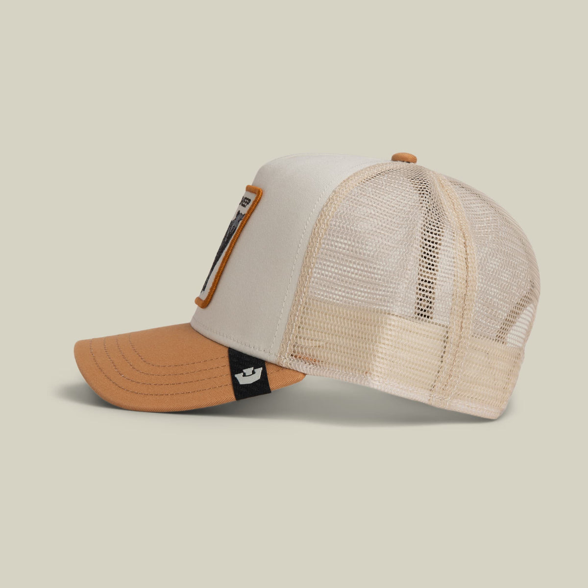 The Goorin Bros. Black Sheep Trucker Mini is a color-blocked trucker hat featuring a cream front panel with leather patch detail, mesh back in cream, and tan orange brim with black fabric accent, displayed on a neutral background.