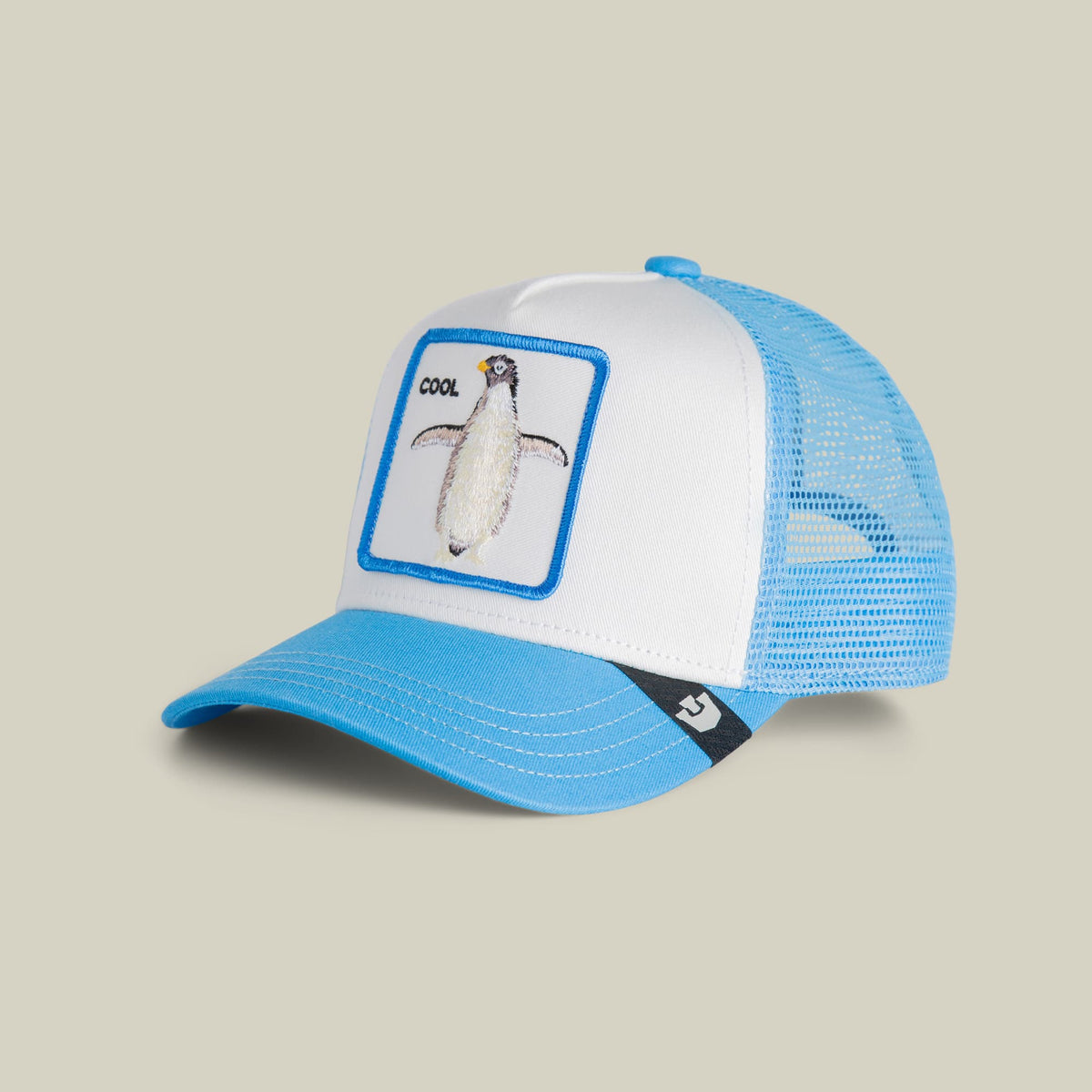 The Goorin Bros. Cool Penguin Mini trucker hat features a white front panel with a blue-bordered meerkat patch, blue mesh back, and blue bill on a neutral background.