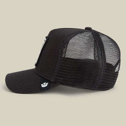 The Goorin Bros. Frenchie Trucker Mini is a black mesh trucker hat with a solid front panel and snapback closure, shown in a side view against a beige background.