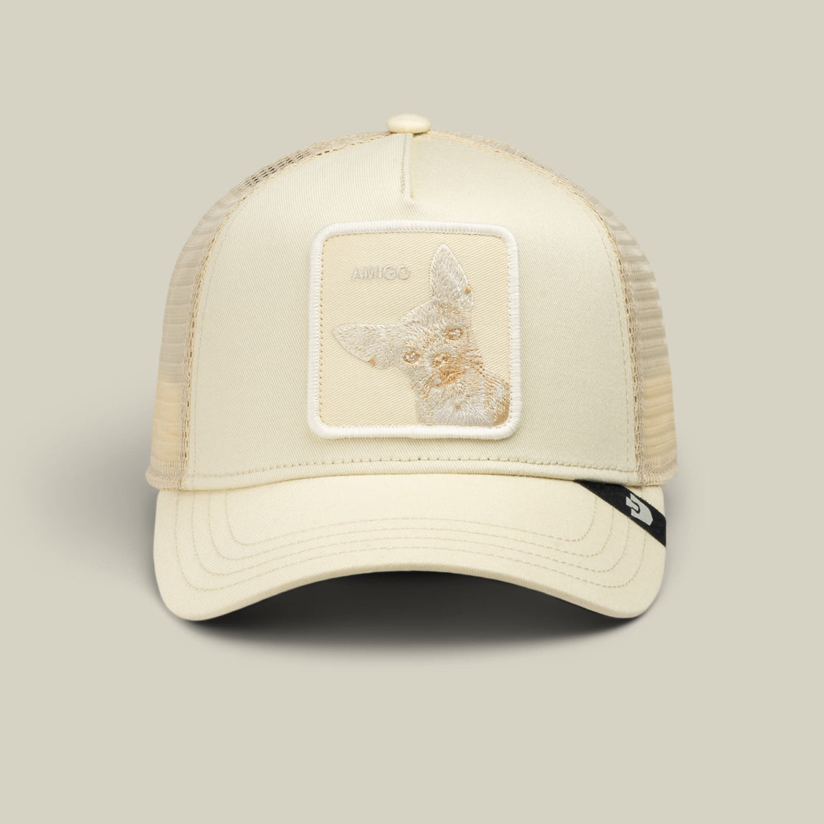 The Goorin Bros. Tonal Amigo Mini is a cream-colored trucker hat with a mesh back and embroidered fox patch on the front panel, displayed against a neutral background.