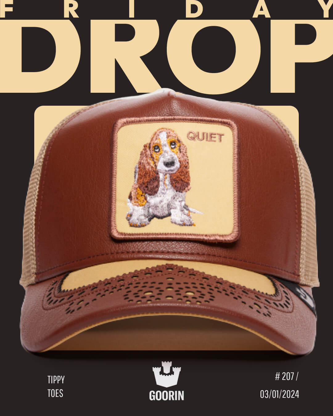 A brown and beige Goorin trucker hat featuring an embroidered basset hound patch labeled QUIET, displayed against a black background with bold FRIDAY DROP text—perfect for fans of American made trucker hats.
