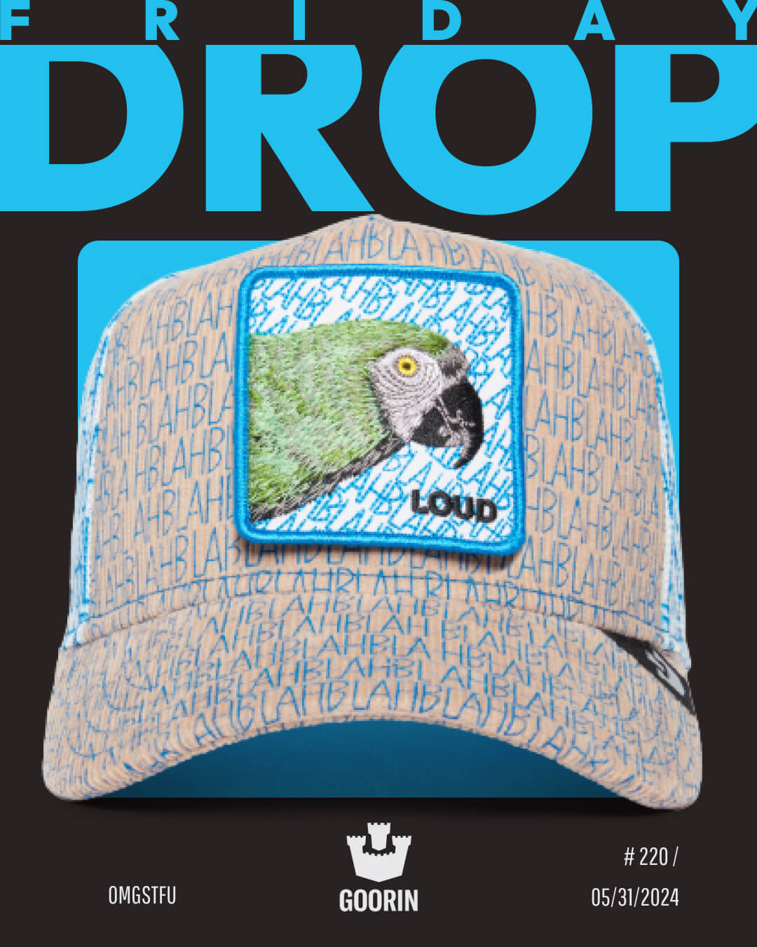 A durable trucker hat with a blue and beige pattern featuring repeated text BLAH, a parrot patch labeled LOUD, and the Goorin Bros. logo; promo for a Friday drop on 05/31/2024.