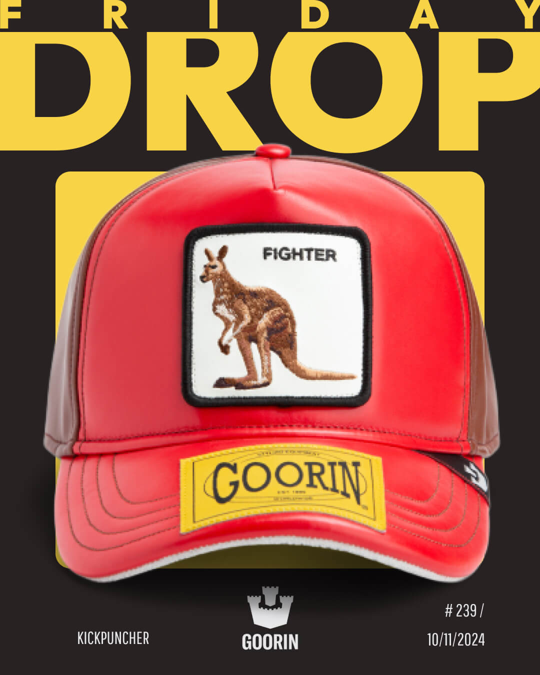 A red Goorin trucker hat with a kangaroo patch labeled Fighter is displayed against a black and yellow graphic background with the words Friday Drop, showcasing the quality of Goorin's durable hats.