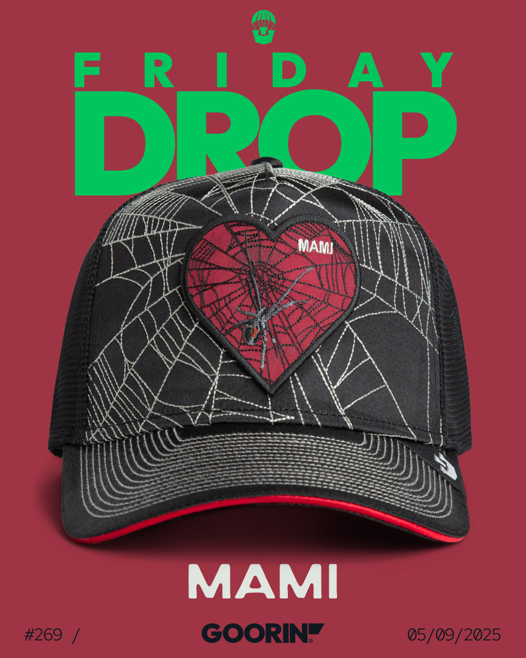 A black American made trucker hat with a spiderweb and heart design labeled MAMI is displayed on a red background with the text FRIDAY DROP, MAMI, and GOORIN. Release date: 05/09/2025.