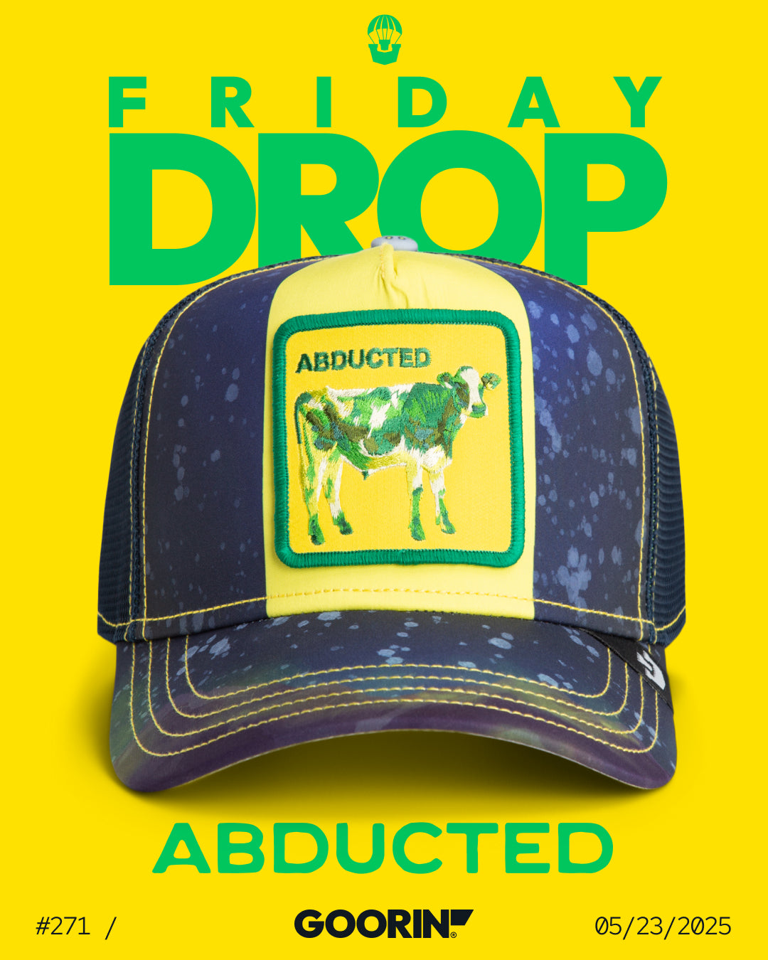 A navy and yellow trucker hat with a patch of a cow labeled Abducted is displayed against a bright yellow background, featuring bold hat designs in the latest Friday Goorin drop on 05/23/2025.