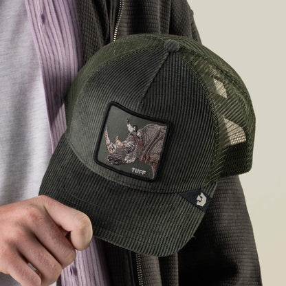 A person holds the Goorin Bros. Corduroy Tuff hat, made from a sturdy polyester-cotton blend in green corduroy, featuring a mesh back and an embroidered rhino patch with “TUFF” stitched beneath it.