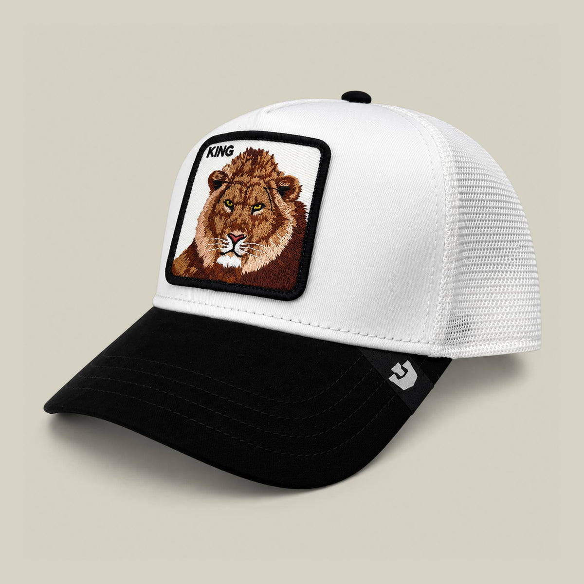 The Goorin Bros. Suede King trucker hat features a white mesh back, black suede bill, and embroidered lion patch with "King" text on the front panel, displayed against a neutral studio background.