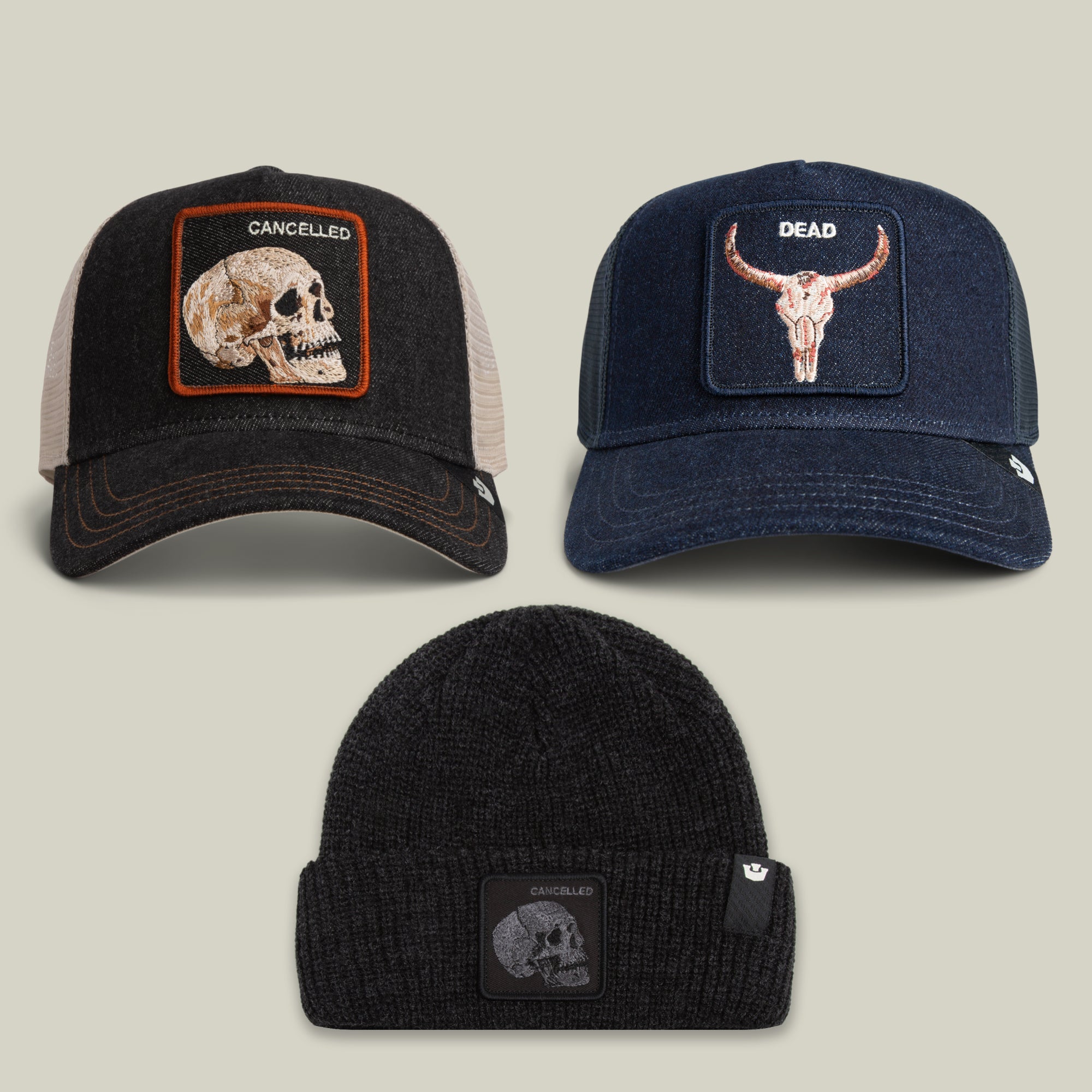 The Fine, Thanks For Asking Bundle by Goorin Bros. features three hats: two trucker caps with embroidered longhorn skull patches labeled CANCELLED and DEAD, and one black knit beanie with a smaller CANCELLED skull patch.