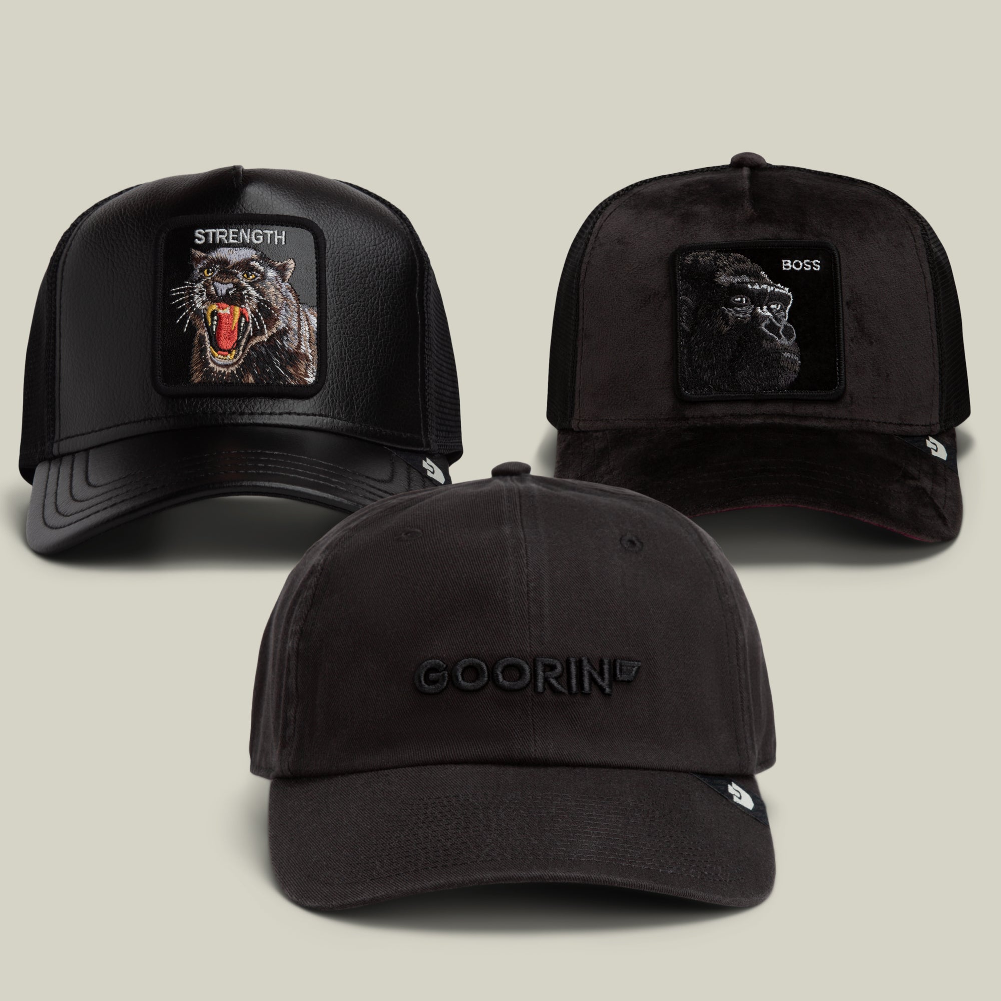The Dark Side Bundle by Goorin Bros. features three black hats: two trucker caps with animal patches—one bold “STRENGTH” wolf patch and another labeled “BOSS”—plus a low-key black dad cap with GOORIN embroidered on the front.