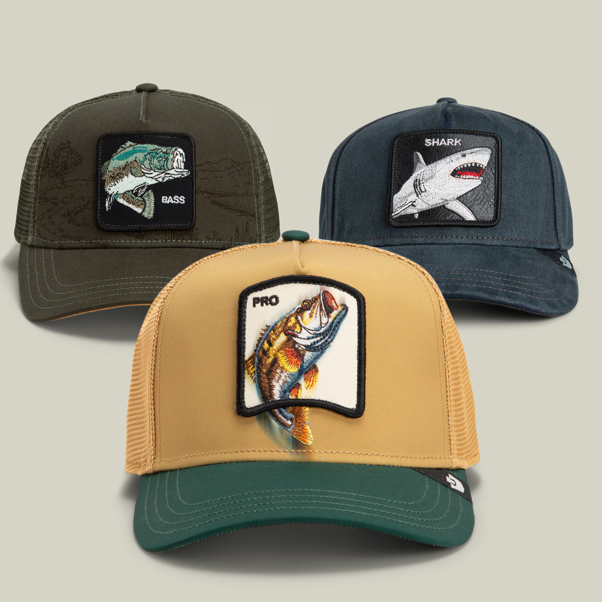 Introducing the WWII (Water World II) Bundle by Goorin Bros.—a trio of ocean-inspired hats, each featuring animal patches: a brown hat with a PRO fish, a green hat with a BASS fish, and a blue hat with a SHARK. All styles are showcased on a plain background.