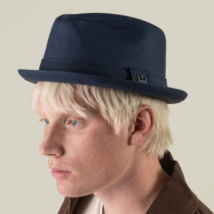 Person with light skin and blond hair wearing the Charlie Pants by Goorin Bros. and a brown jacket, pictured in profile against a plain background.