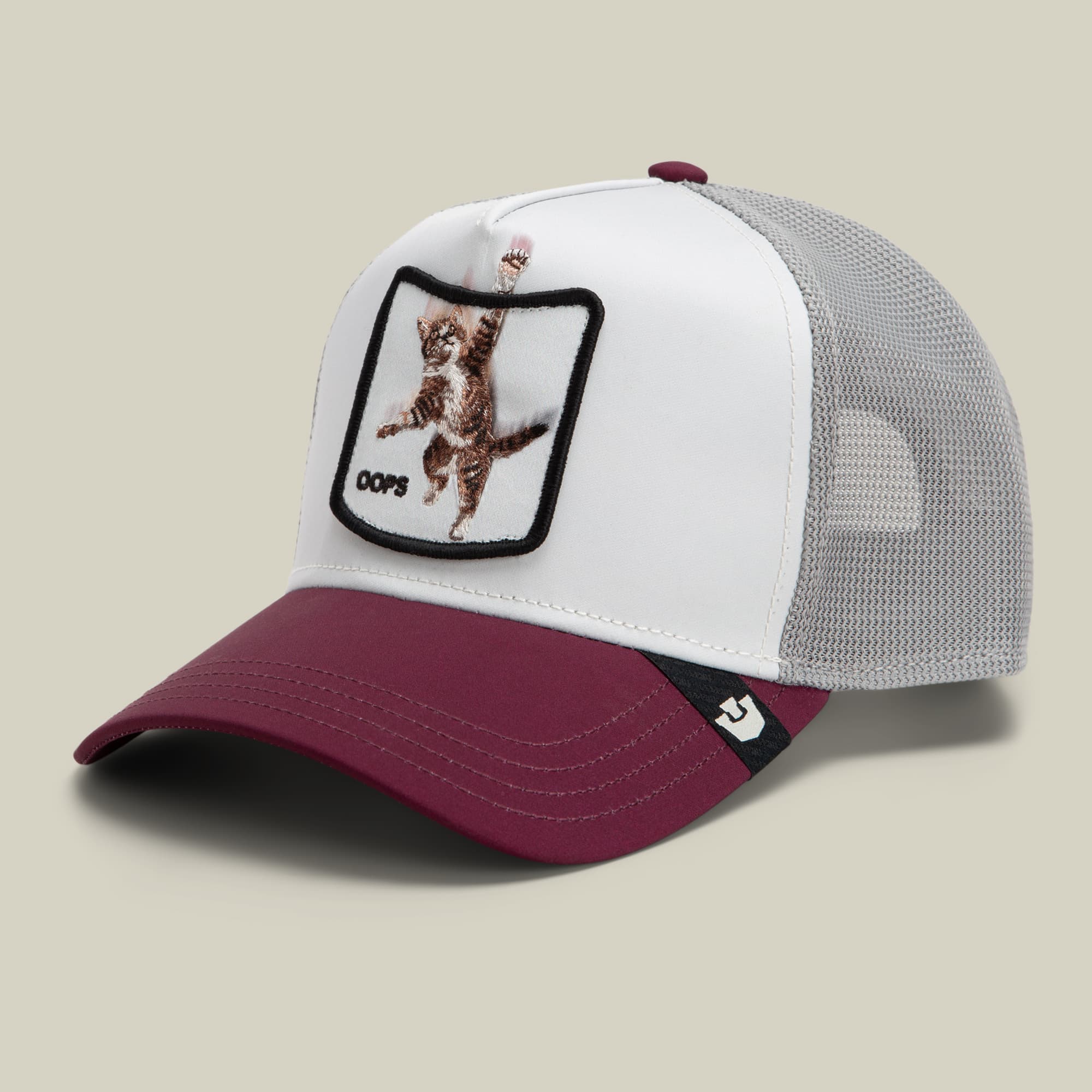 The Goorin Bros. Migration - Oops trucker hat features a white front panel with embroidered bear graphic patch, gray mesh back, and burgundy bill, shown as a studio product shot against a neutral background.